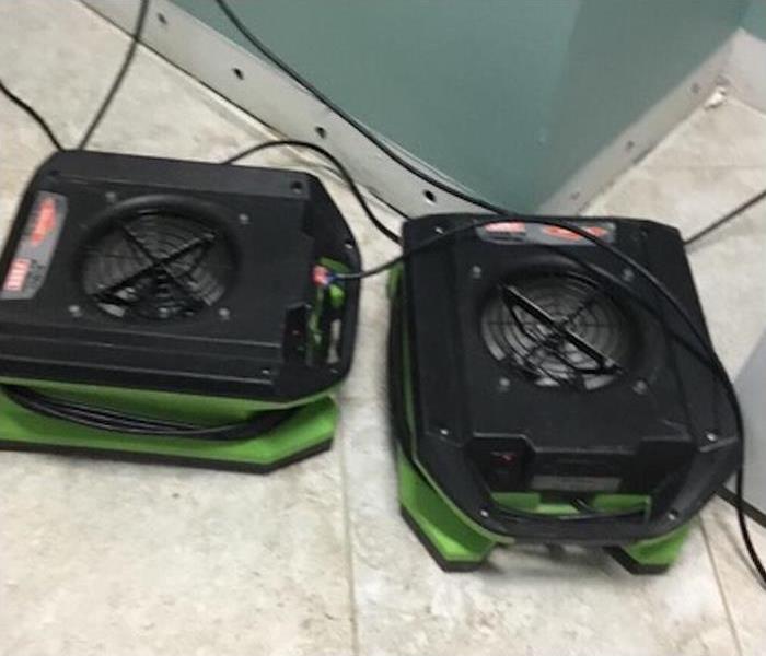 two air movers placed beside baseboards